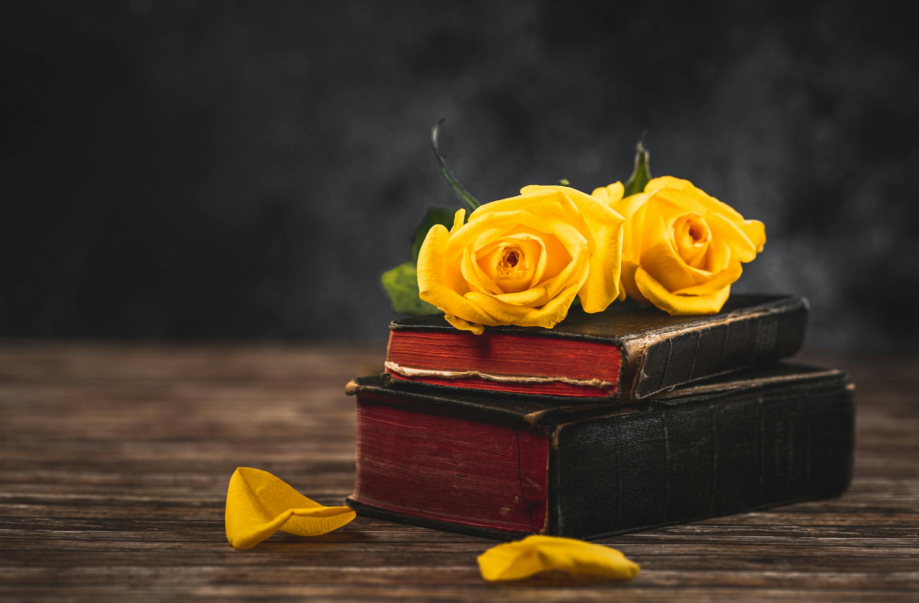 yellow roses on top of books